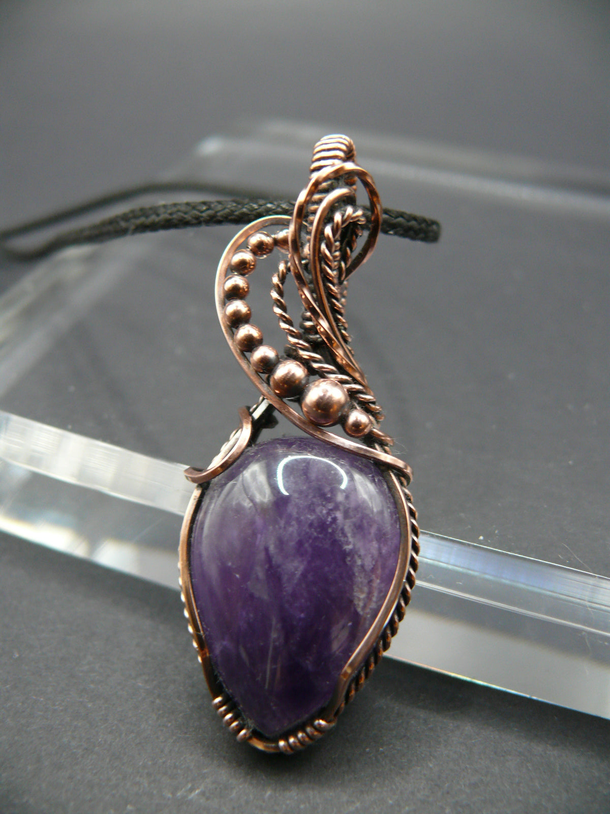 Amethyst gemstone pendant wrapped in antiqued copper