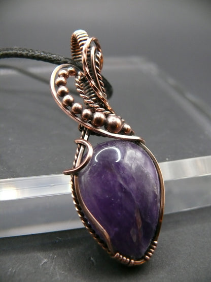 Amethyst gemstone pendant wrapped in antiqued copper