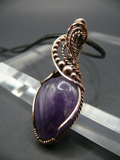 Amethyst gemstone pendant wrapped in antiqued copper