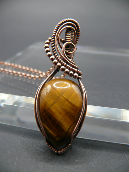 Tiger eye gemstone pendant wrapped in copper