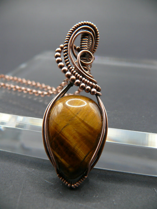 Tiger eye gemstone pendant wrapped in copper