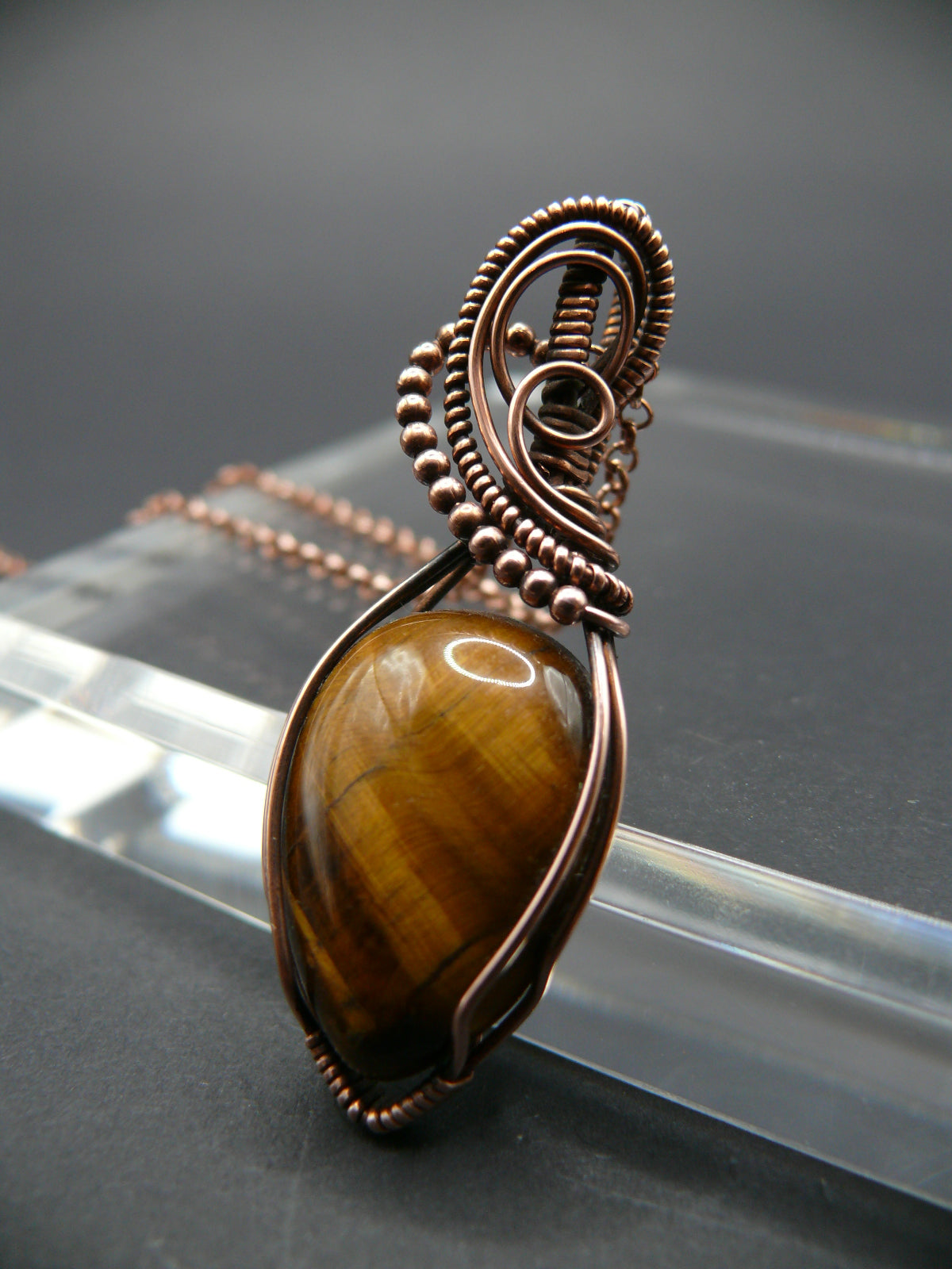 Tiger eye gemstone pendant wrapped in copper