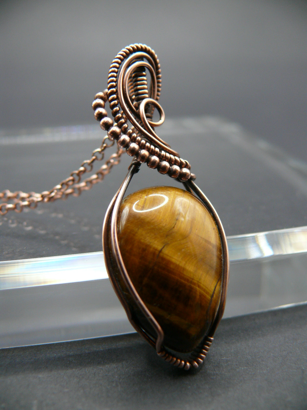 Tiger eye gemstone pendant wrapped in copper