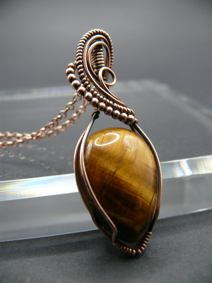 Tiger eye gemstone pendant wrapped in copper