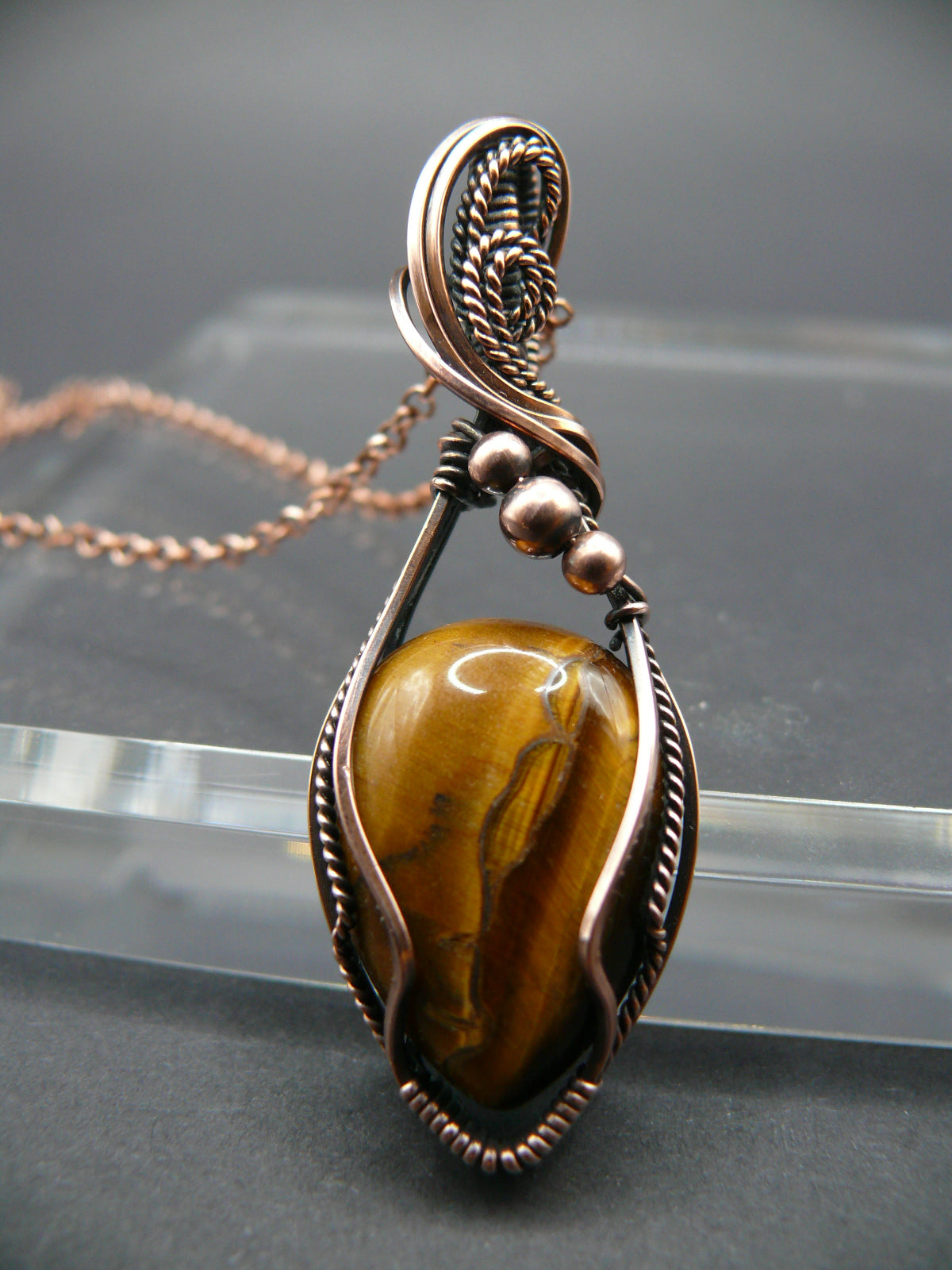 Tiger eye gemstone pendant wrapped in antiqued copper