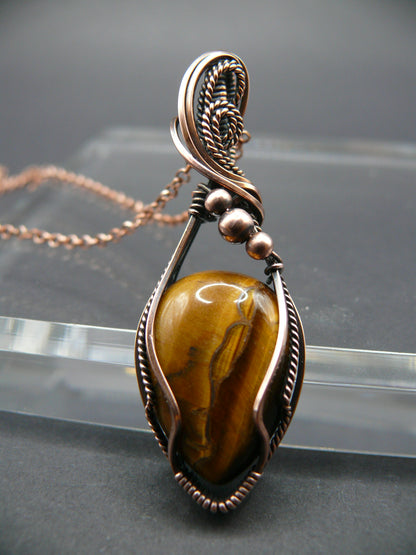 Tiger eye gemstone pendant wrapped in antiqued copper