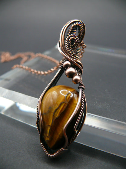 Tiger eye gemstone pendant wrapped in antiqued copper