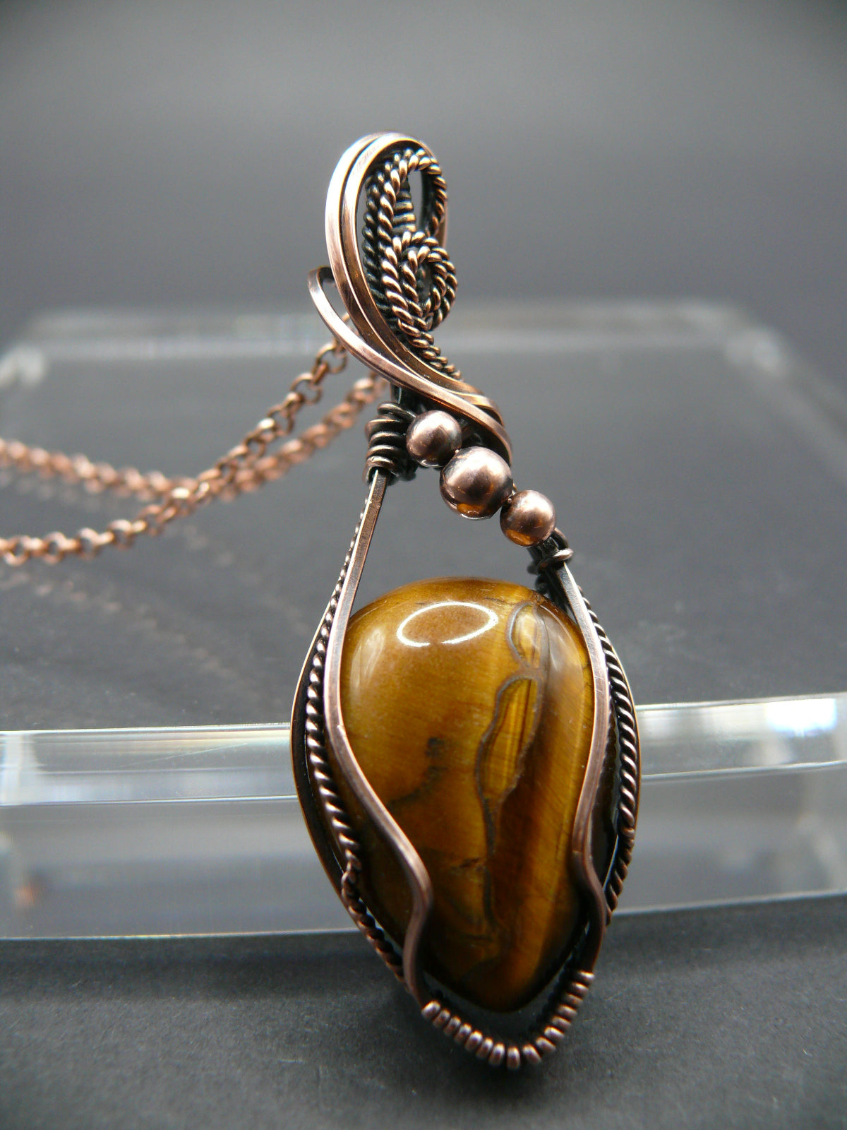 Tiger eye gemstone pendant wrapped in antiqued copper