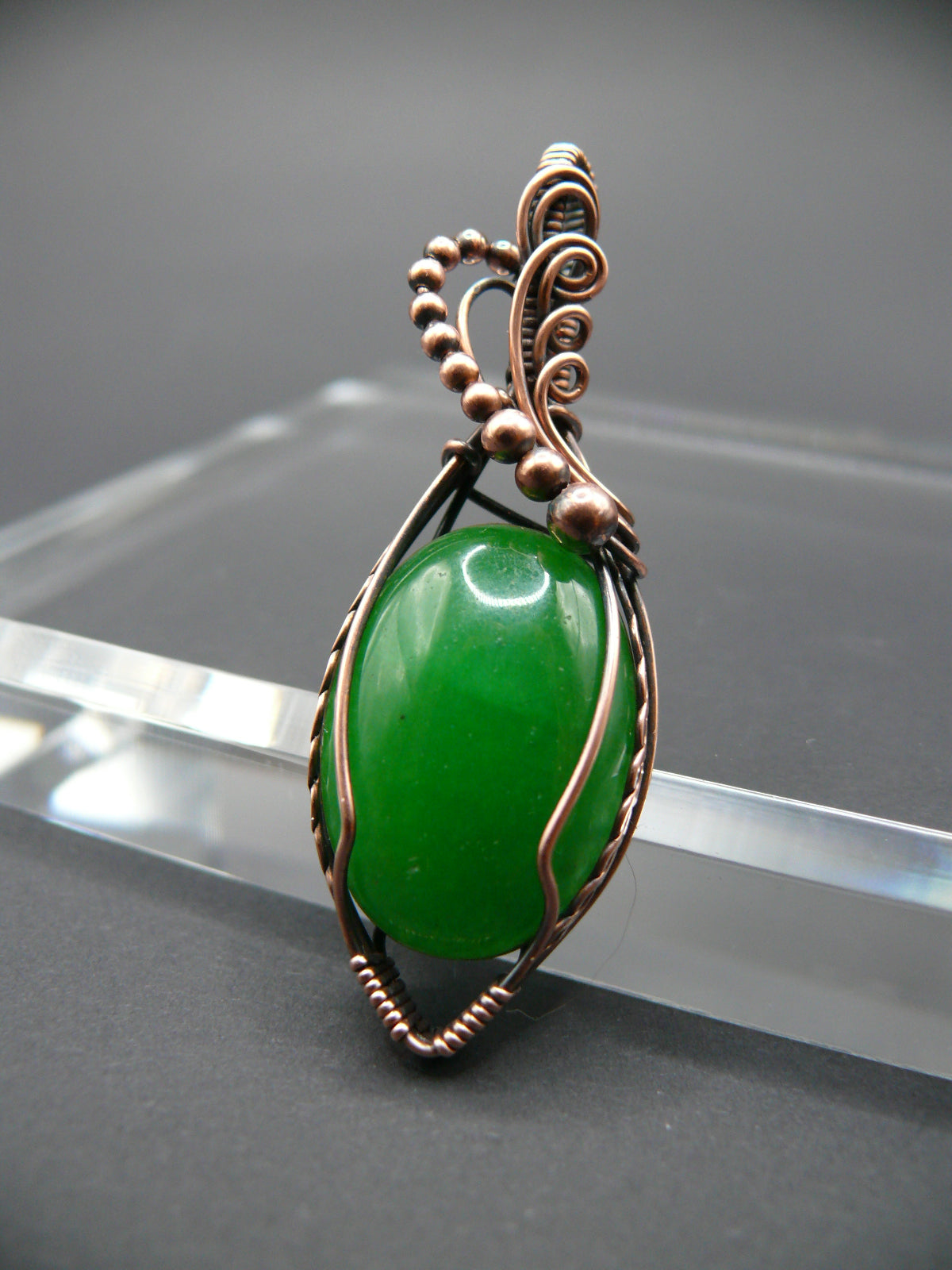 Copper-wrapped jade gemstone pendant