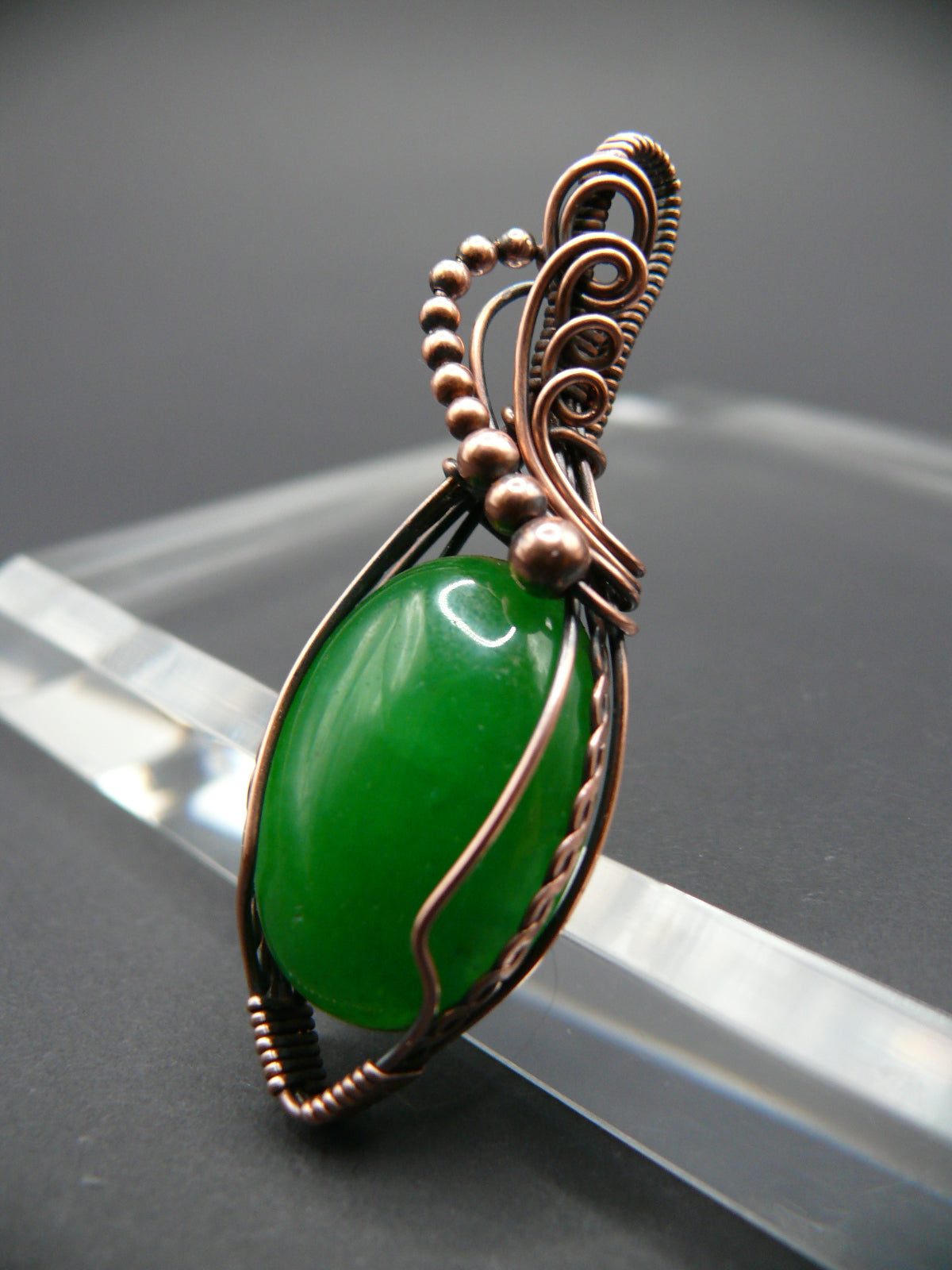 Copper-wrapped jade gemstone pendant