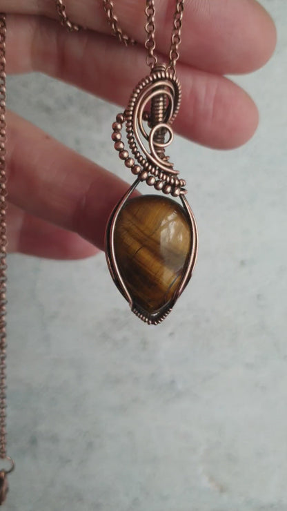 Tiger eye gemstone pendant wrapped in copper